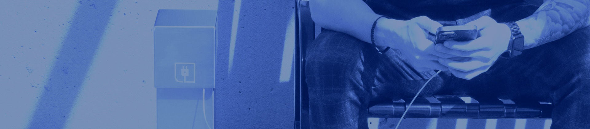 Homme séance sur banc charge téléphone avec puissance piédestal